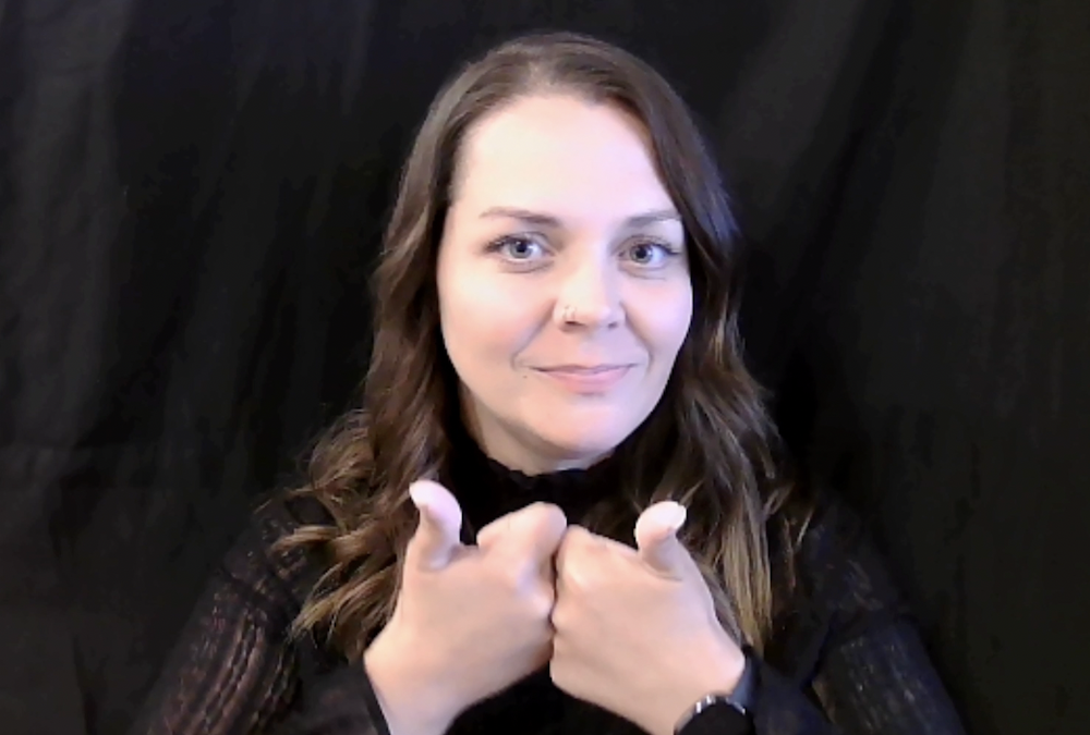Screenshot from the Fingerspelling Tutorial Part 2 of a woman fingerspelling.